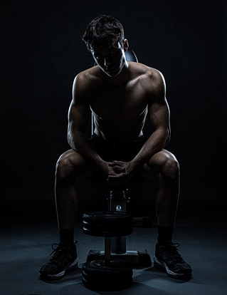 Fotografía fitness en estudio en Madrid Fotografía fitness profesional en Madrid, retrato masculino con iluminación dramática en estudio y pose de fuerza
